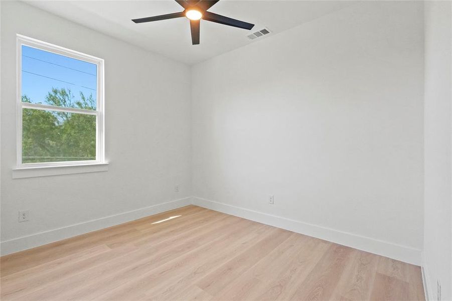 Spare room featuring light wood-style flooring and ceiling fan Spare room featuring light wood-style flooring and ceiling fan