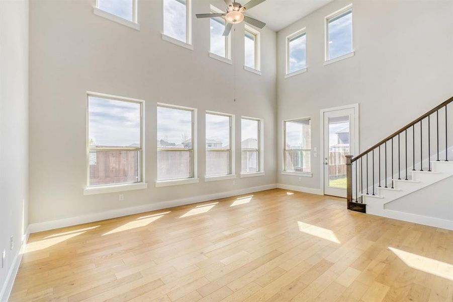 Unfurnished living room featuring ceiling fan and light wood-style floors
