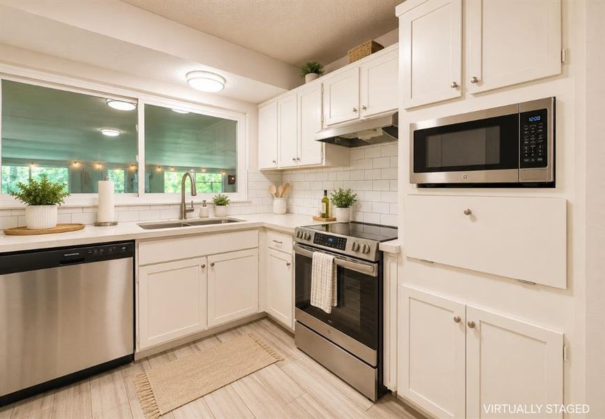 Kitchen featuring white shaker cabinetry, stainless steel appliances, light-colored countertops, and subway tile backsplash