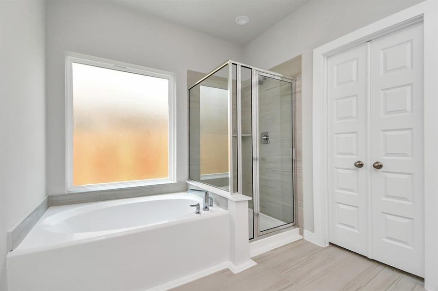 Enjoy a walk-in shower with tile surround, a separate garden tub with custom detailing. Sample photo, as built color and selections will vary.