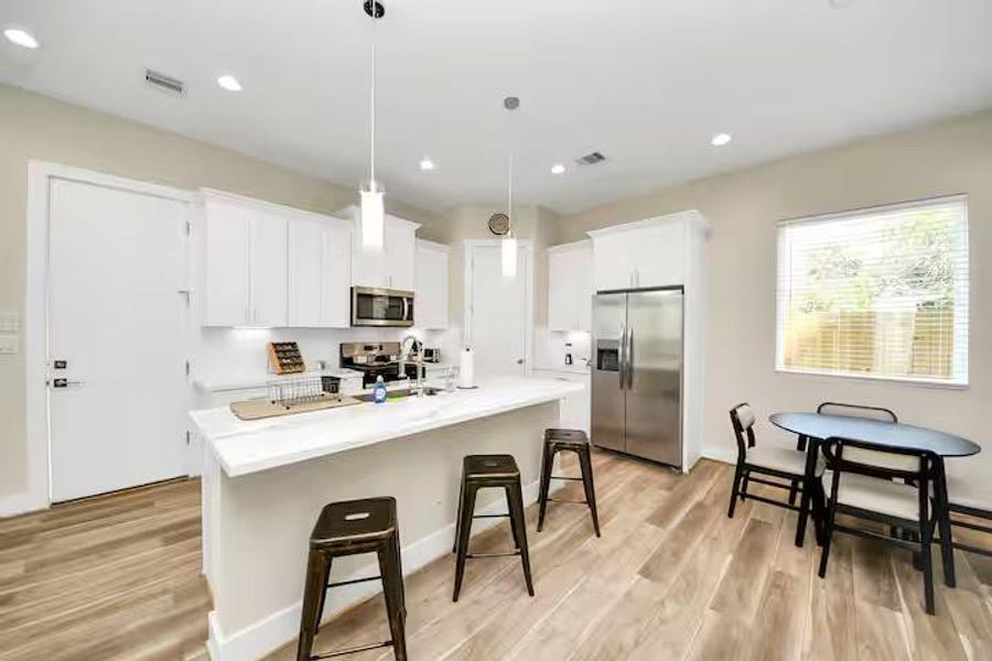 A clean, bright kitchen pairs white cabinetry and countertops with stainless steel appliances for a look that is easy to move into and make your own.