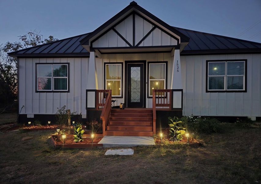 View of front of property with board and batten siding, a standing seam roof, and a metal roof