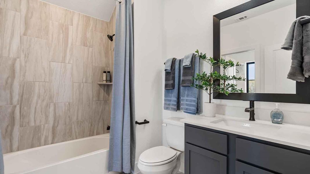 A secondary bathroom with a standing tub, one sink vanity, and a window for natural lighting