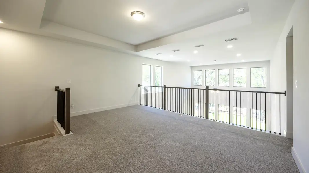 Carpeted spare room featuring recessed lighting, a wealth of natural light, visible vents, and baseboards Carpeted spare room featuring recessed lighting, a wealth of natural light, visible vents, and baseboards