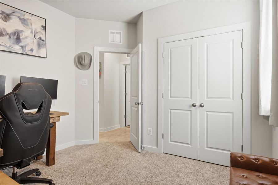 Office space with light colored carpet and baseboards