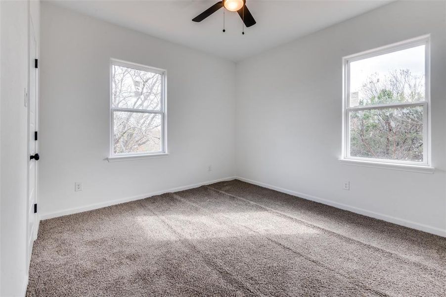 Spare room featuring carpet and ceiling fan