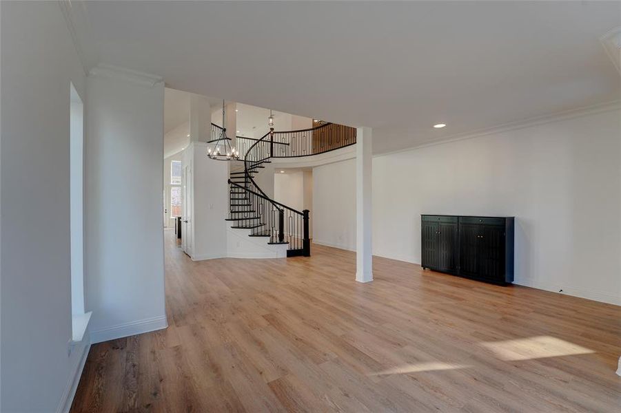 Living room with baseboards, stairway, vinyl finished floors, and ornamental molding