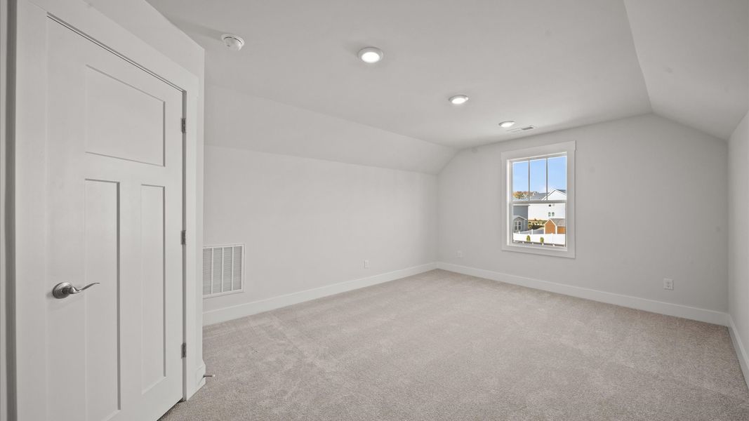 Elegant bedroom retreat featuring soft carpet and oversized windows that create a bright, welcoming space