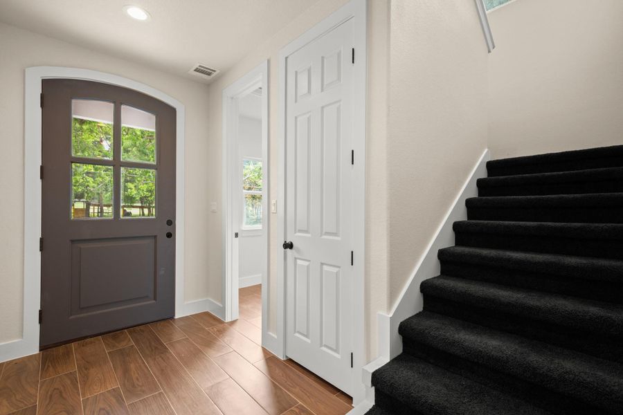 Entryway with recessed lighting, stairs, and dark wood-style floors
