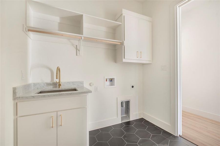 Laundry room featuring hookup for a washing machine, cabinet space, hookup for an electric dryer, dark tile patterned floors, and gas dryer hookup Laundry room featuring hookup for a washing machine, cabinet space, hookup for an electric dryer, dark tile patterned floors, and gas dryer hookup