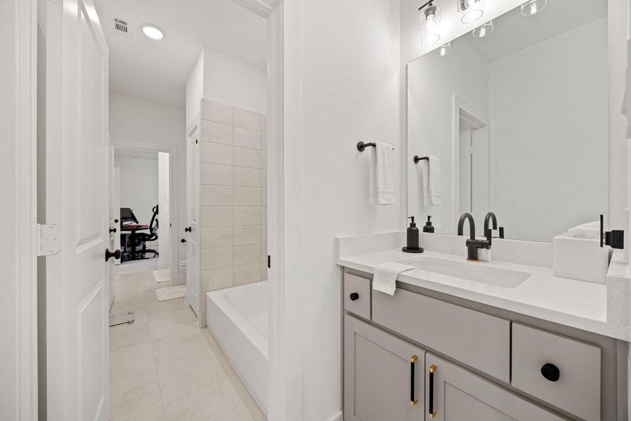 Another view of the jack and jill bathroom located upstairs. There's a view into an adjacent room, suggesting a well-connected layout.