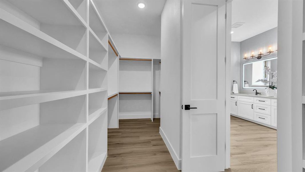 Spacious closet with light wood finished floors