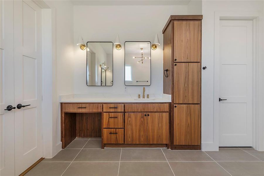 Wood-finish vanity with a white countertop and gold-tone fixtures Wood-finish vanity with a white countertop and gold-tone fixtures