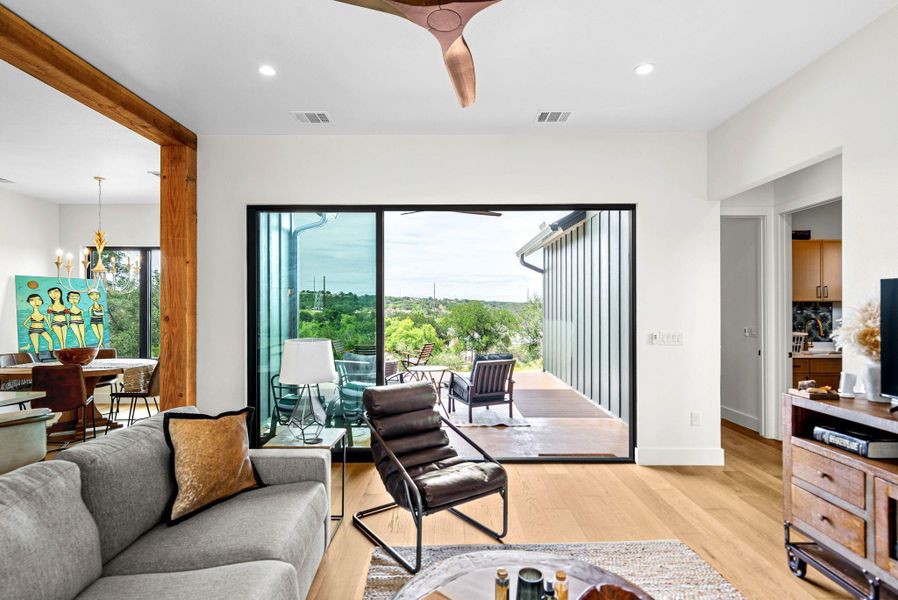 A wide sliding glass door frames long-range views from this open living area with hardwood floors.