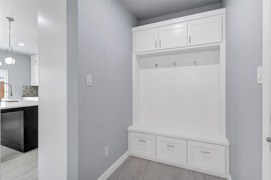 Mudroom featuring baseboards and a sink
