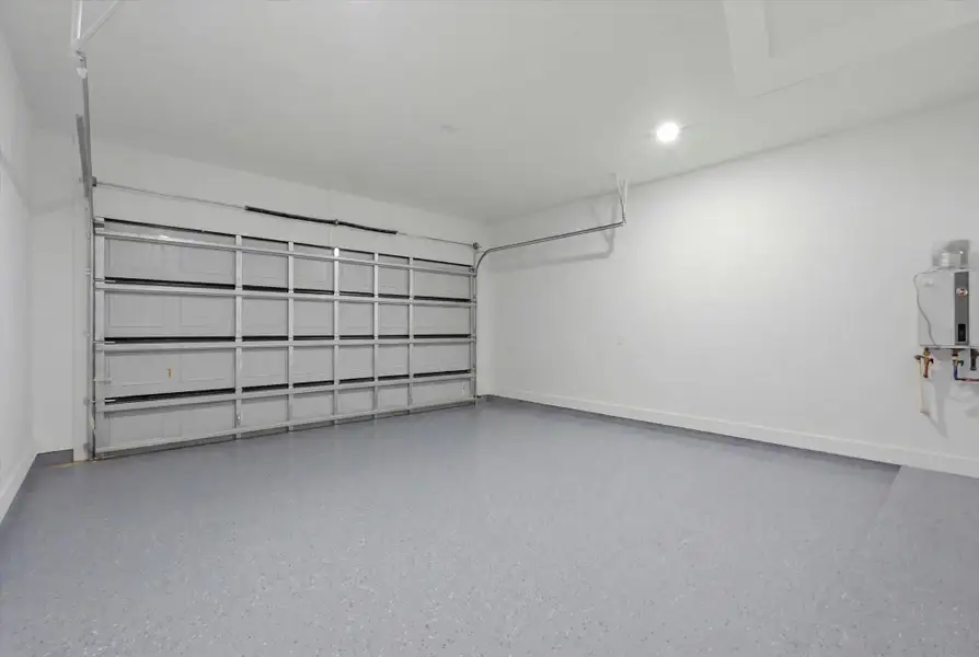 Pristine & Ready. This ultra-clean, finished two-car garage boasts a professional, easy-to-clean epoxy-coated floor, bright recessed lighting, and a modern, energy-efficient tankless water heater—proving that no detail was spared!
