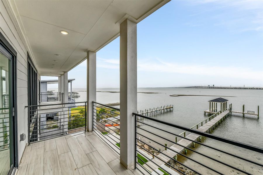 This covered bayfront porch may become the favorite room outside. Catch the breeze, take in the water and settle in for sunsets with the private pier just beyond the railing. This covered bayfront porch may become the favorite room outside. Catch the breeze, take in the water and settle in for sunsets with the private pier just beyond the railing.