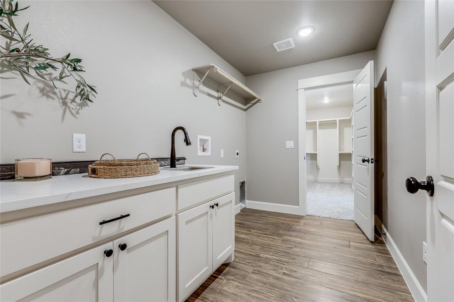 Laundry area with hookup for a washing machine, dark wood-style flooring, hookup for an electric dryer, and cabinet space Laundry area with hookup for a washing machine, dark wood-style flooring, hookup for an electric dryer, and cabinet space