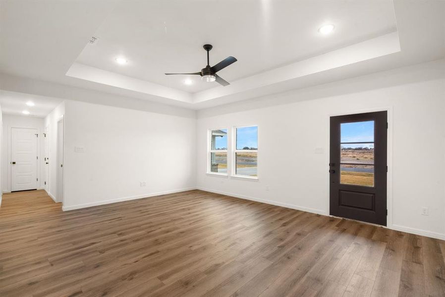 Spare room with dark hardwood / wood-style floors, ceiling fan, and a tray ceiling Spare room with dark hardwood / wood-style floors, ceiling fan, and a tray ceiling