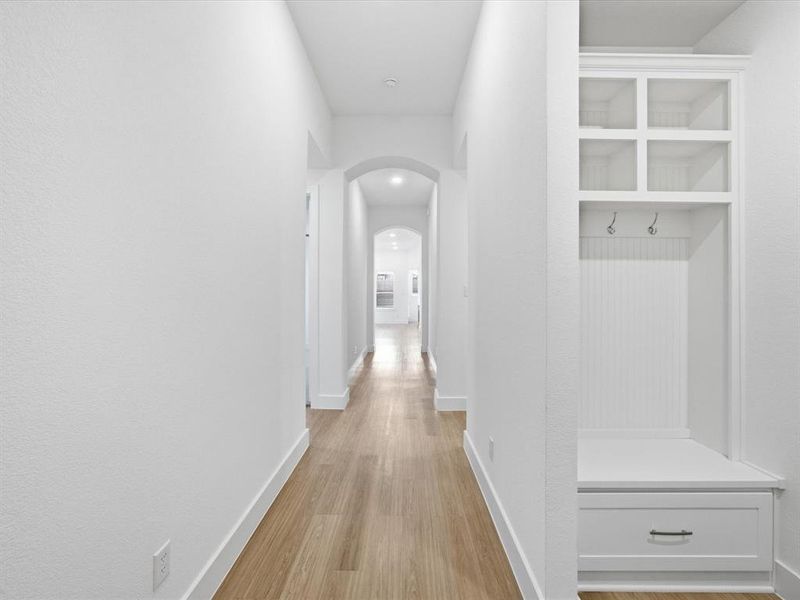 Hall with light wood-type flooring and arched walkways