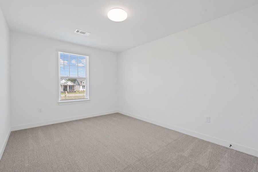 Neutral gray carpeting, white walls, white window trim, and a flush-mount ceiling light fixture