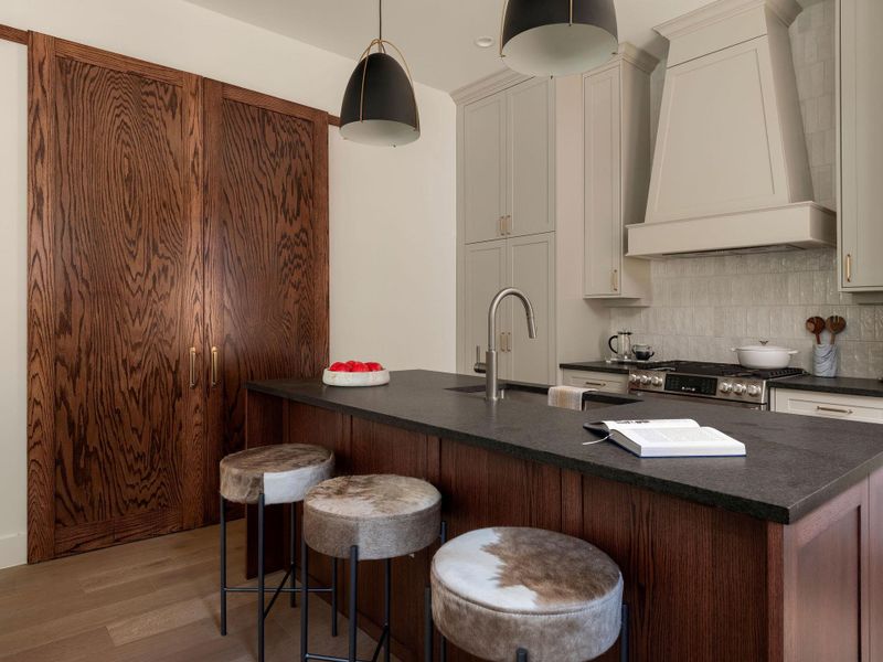Culinary aspirations meet sophisticated design in this kitchen, featuring sleek cabinetry and a generously sized island.