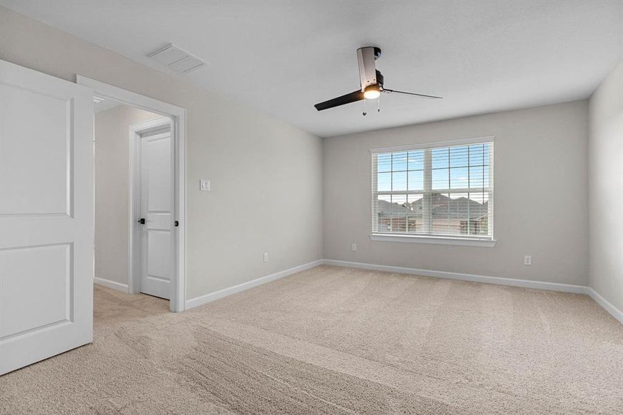 The primary bedroom has a large window, letting in plenty of natural light.