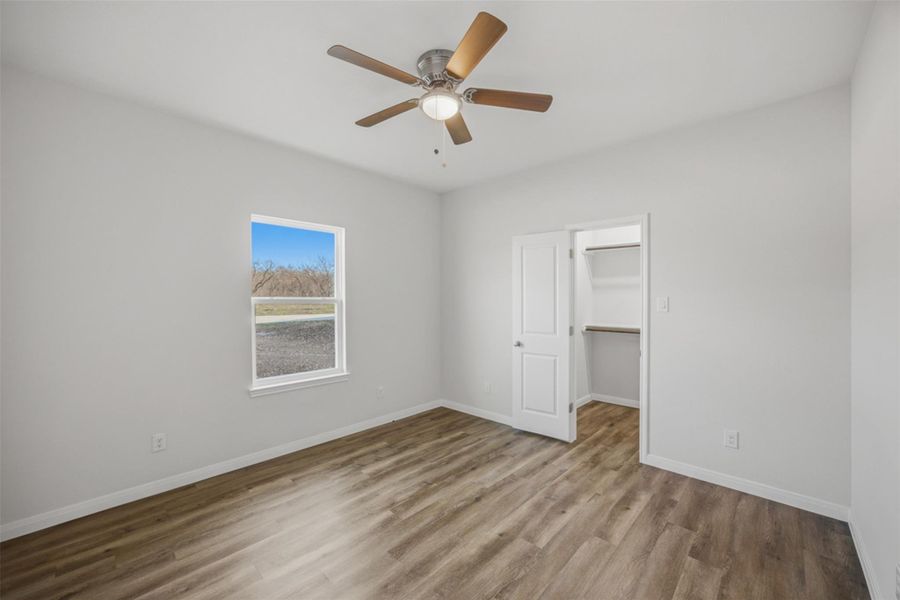 A quiet retreat with a single window offering pastoral views, enhanced by efficient overhead lighting and rich wood-toned flooring.
