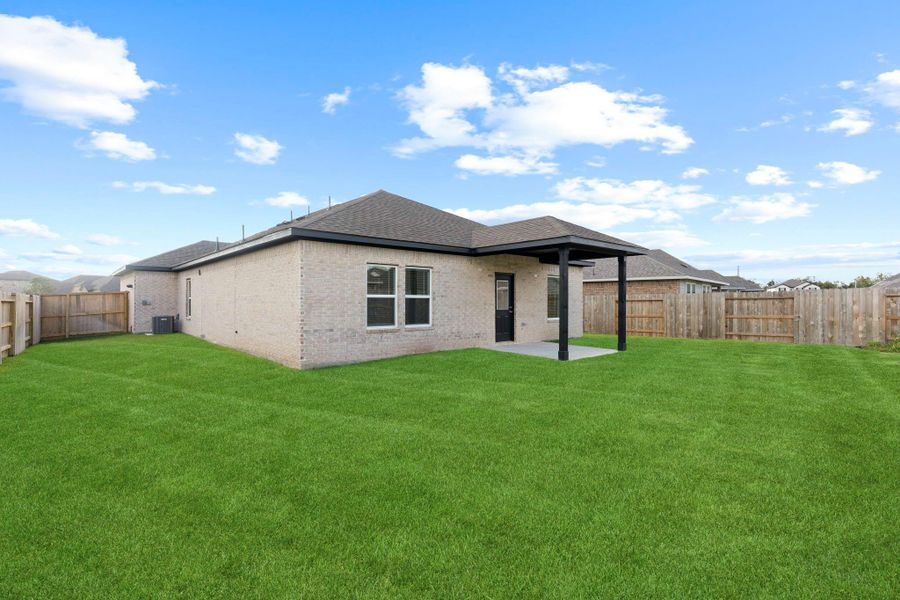 A view from the back of the home shows the lovely brick exterior, yes, all brick home for less upkeep!  Notice how wide the huge green yard, giving you a full picture of the home’s peaceful and inviting setting.