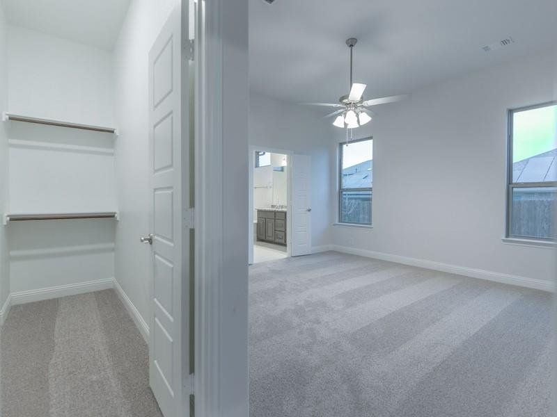 Spare room featuring light colored carpet and ceiling fan