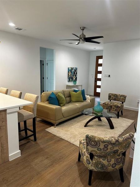 Living room with hardwood / wood-style flooring and ceiling fan