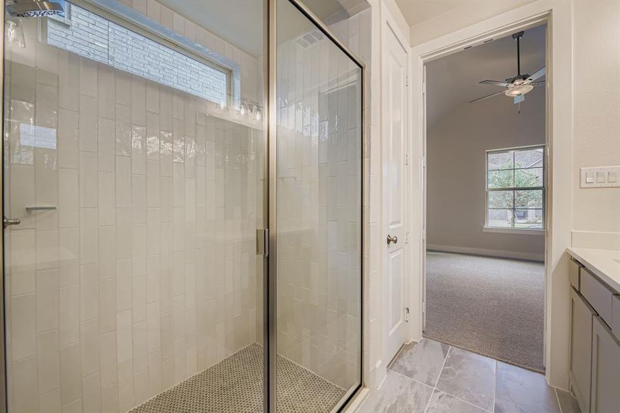 Bathroom with plenty of natural light, a stall shower, vanity, and vaulted ceiling Bathroom with plenty of natural light, a stall shower, vanity, and vaulted ceiling