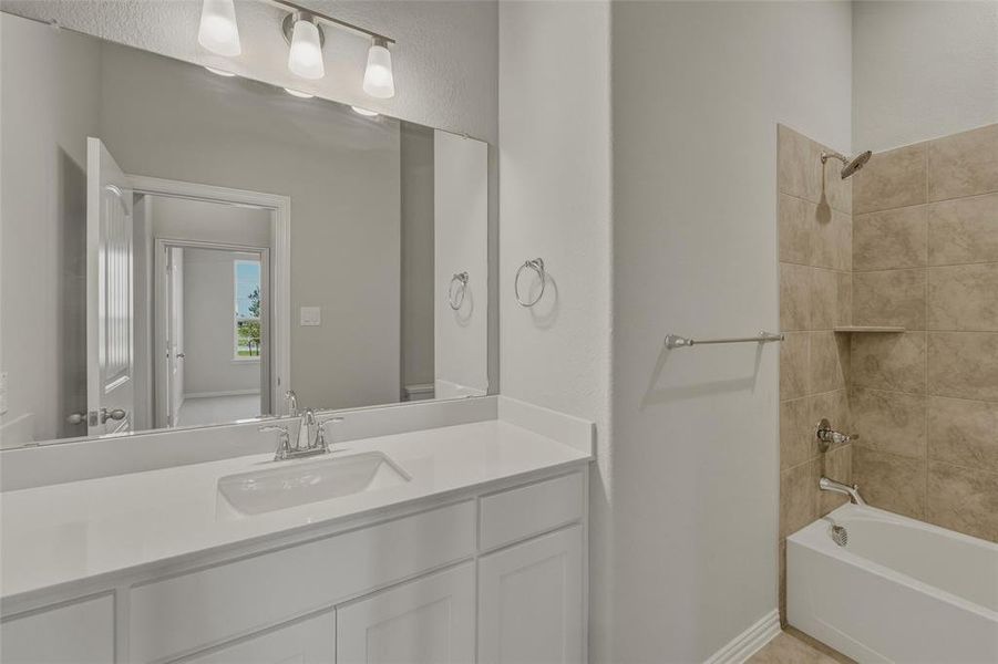 Bathroom featuring a single vanity with a white countertop and undermount sink, chrome faucet, and a large wall-mounted mirror Bathroom featuring a single vanity with a white countertop and undermount sink, chrome faucet, and a large wall-mounted mirror