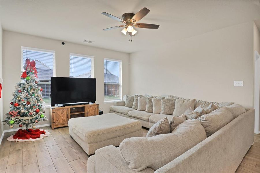 Living room featuring ceiling fan and light hardwood / wood-style flooring