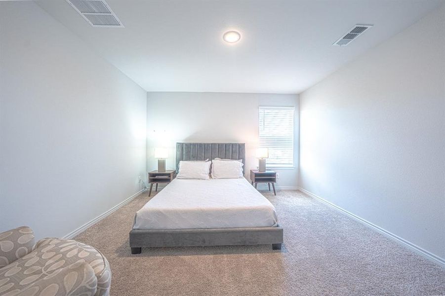 Bedroom featuring carpet and baseboards