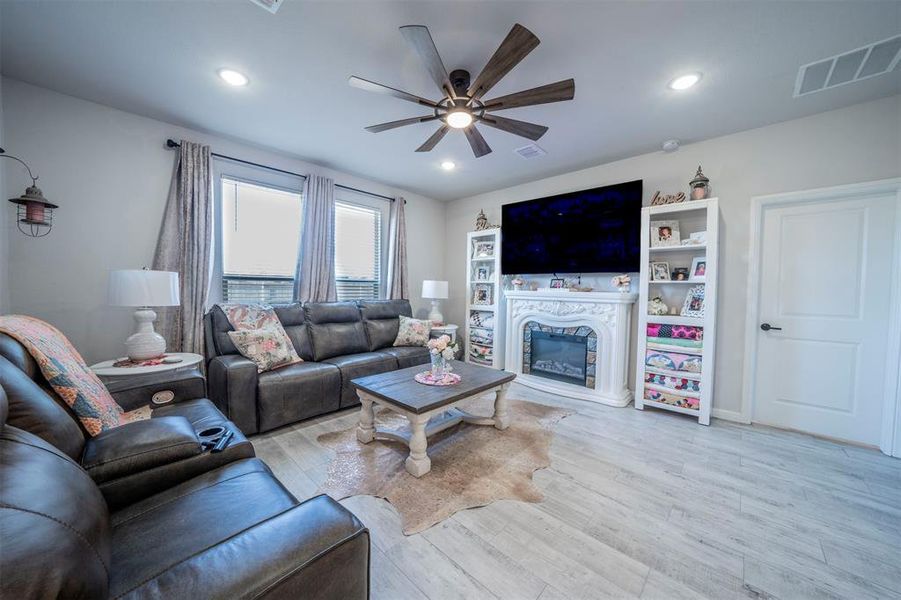 Living room with light hardwood / wood-style flooring and ceiling fan