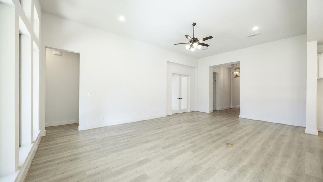 Unfurnished living room with light wood finished floors, recessed lighting, ceiling fan, and a chandelier