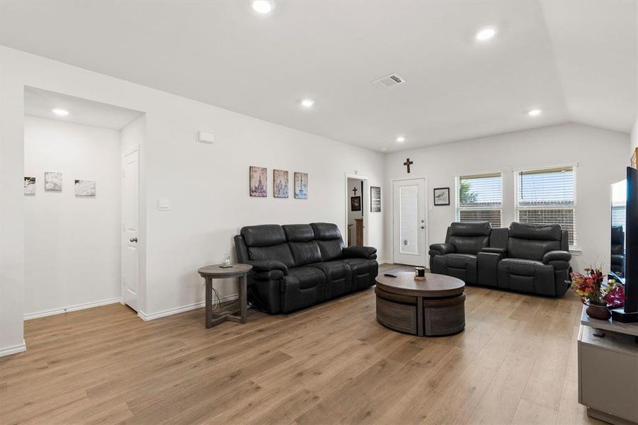 Living room with light wood-style floors, recessed lighting, and vaulted ceiling Living room with light wood-style floors, recessed lighting, and vaulted ceiling