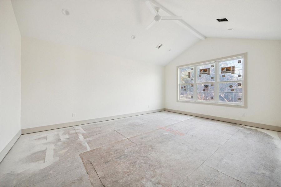 PRIMARY BEDROOM - A spacious primary bedroom is defined by vaulted ceiling lines, oversized windows, and a calm neutral palette that creates a relaxing retreat. Generous wall space and natural light allow for flexible furniture placement while maintaining an open, airy feel. -- Construction as of 1/5/26