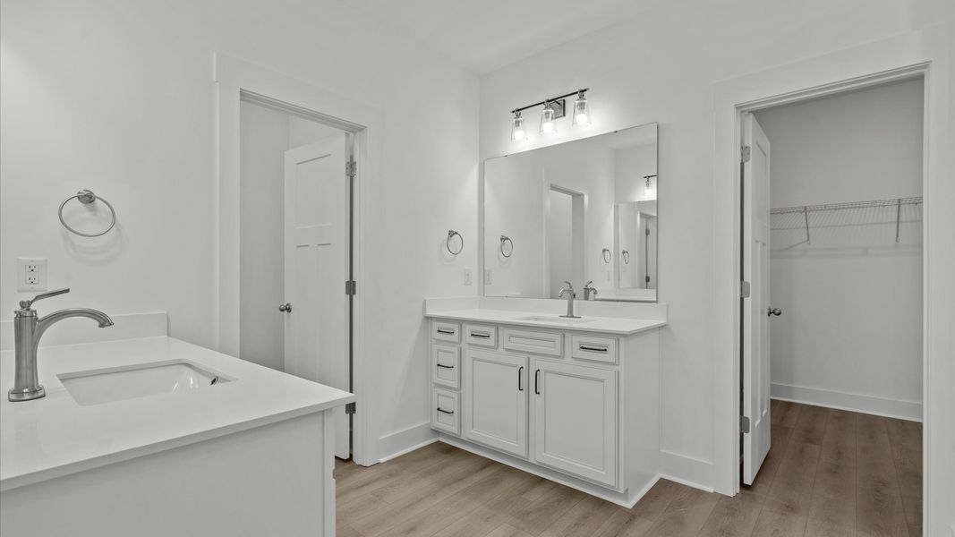 First-rate primary bathroom offering an elegant tiled walk-in Roman shower and separate vanities with superior style