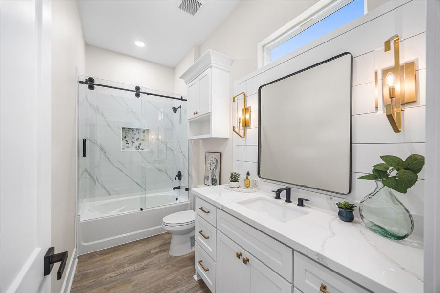 Just Off the Family Room is One of Two Secondary Full Bathroom with Beautiful Modern Fixtures and Sliding Glass Shower Enclosure.