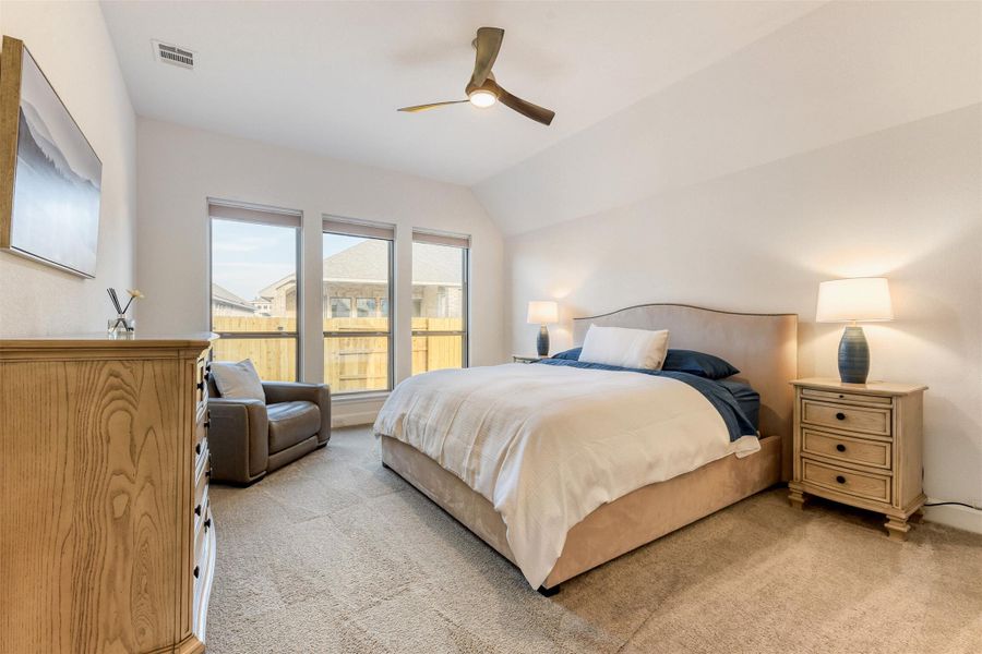 Bedroom featuring light colored carpet, a ceiling fan, and lofted ceiling