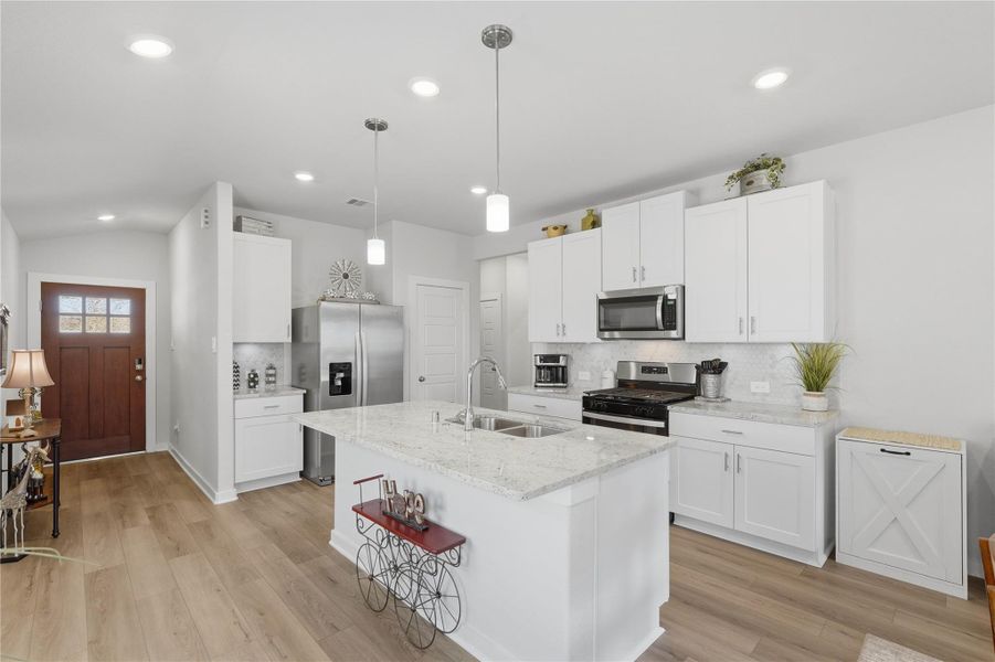 The kitchen is a chefs dream, offering large cabinets, stainless steel appliances, an over-sized island and a coffee bar.