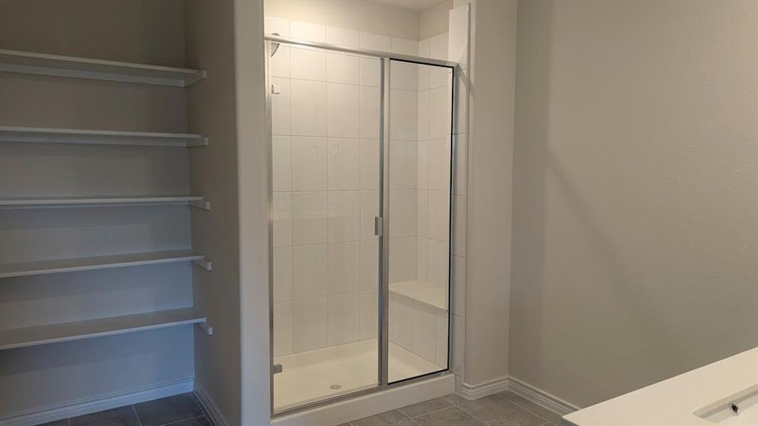 Bathroom featuring a shower stall and tile patterned flooring Bathroom featuring a shower stall and tile patterned flooring