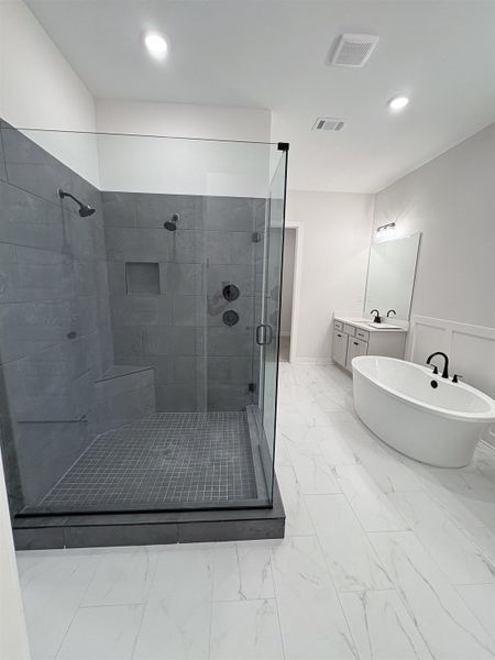 Expansive shower with dark gray tile, built-in bench, and black fixtures Expansive shower with dark gray tile, built-in bench, and black fixtures