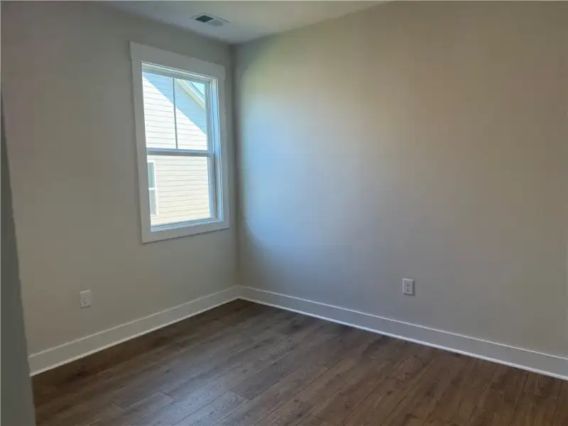 Rich wood-look flooring and a single window define