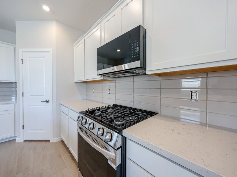 A kitchen with white cabinets.