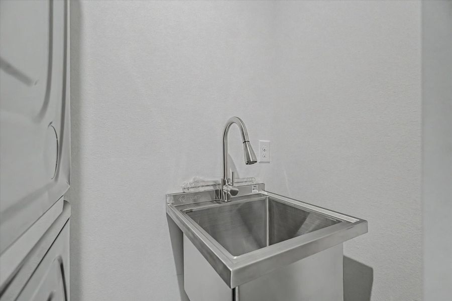 The laundry room features a utility sink and a convenient storage closet.