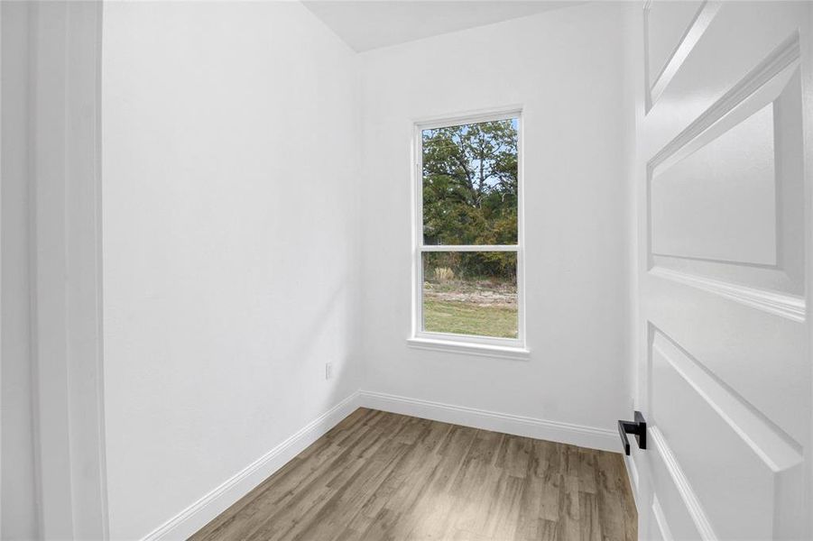 Spare room featuring light wood-style flooring and baseboards Spare room featuring light wood-style flooring and baseboards