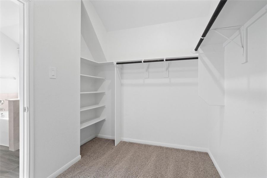 The primary suite features a generous walk-in closet equipped with functional hanging rods and shelving. The primary suite features a generous walk-in closet equipped with functional hanging rods and shelving.